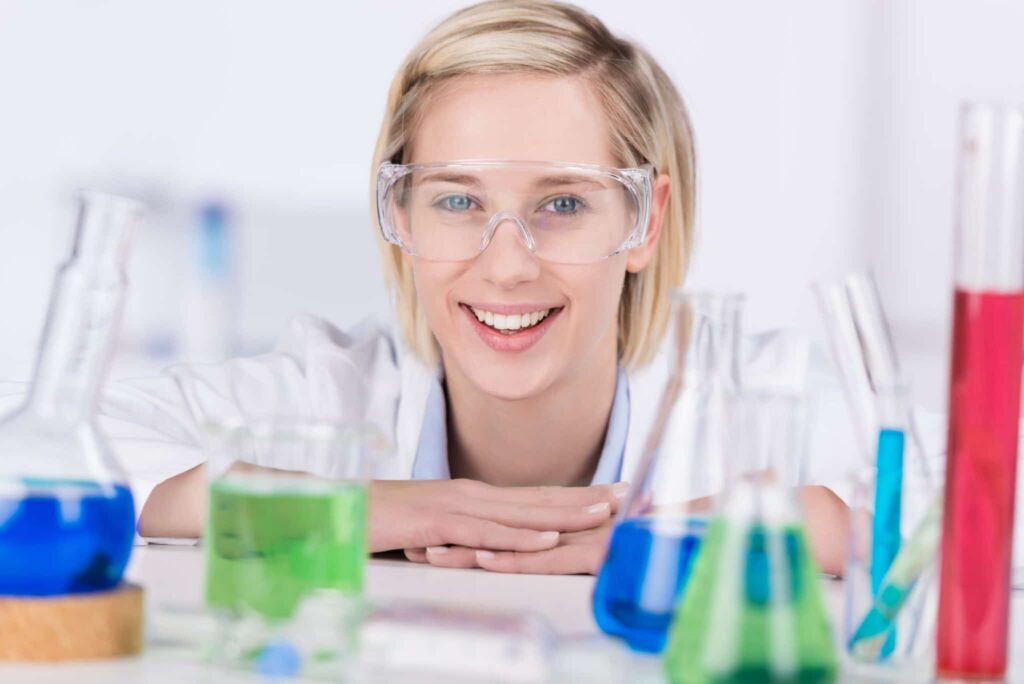 Chemielaborant/in / Frau mit Brille und Reagenzgläsern